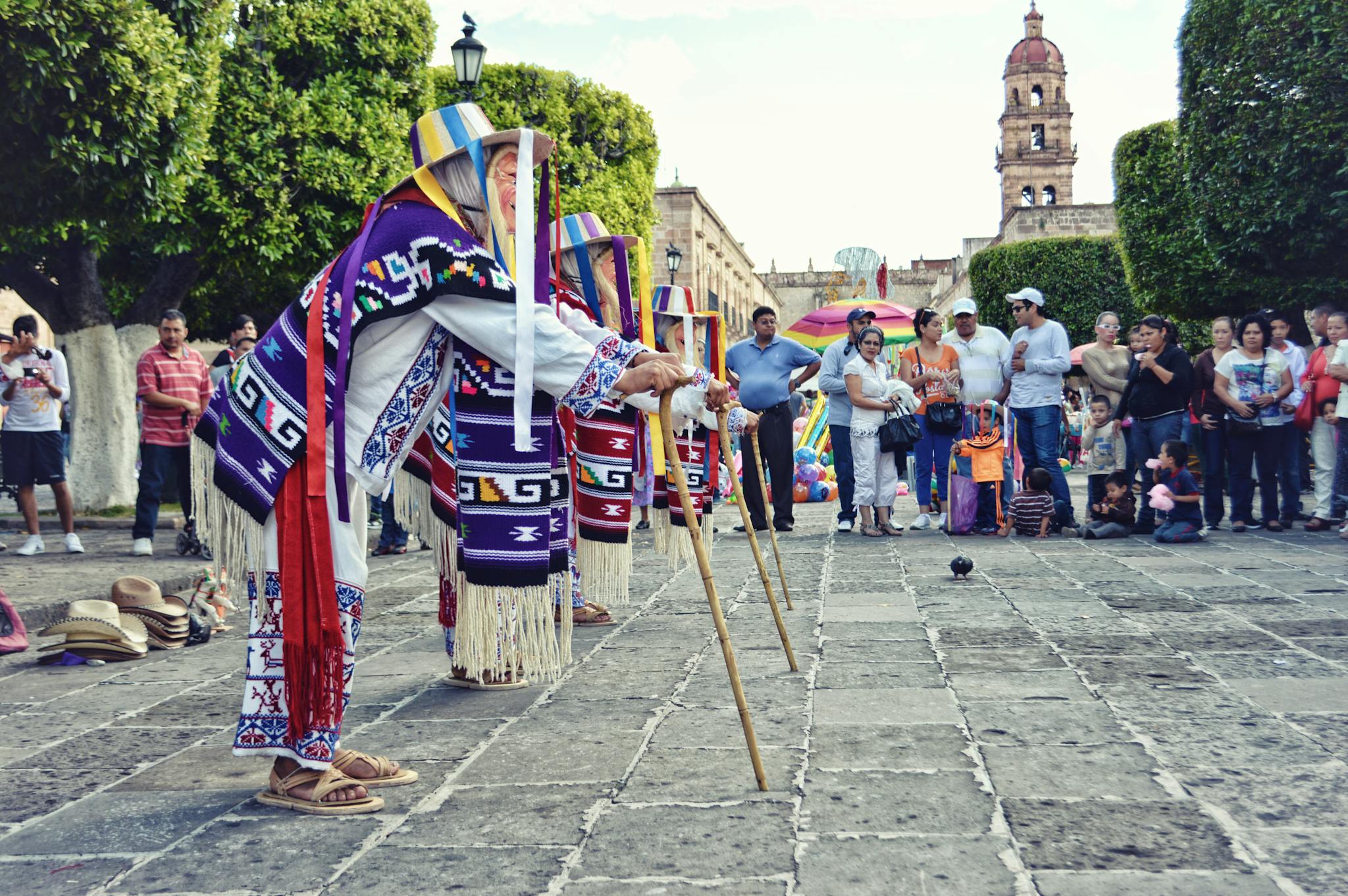 Colorful traditional dance performance in city square, showcasing cultural attire and lively atmosphere.
